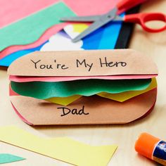 some crafting supplies are laying on a table with paper and markers, scissors, and glue