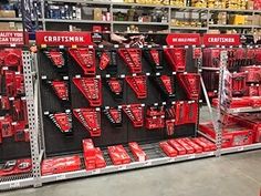 a display in a store filled with lots of red tools and accessories on shelves next to each other