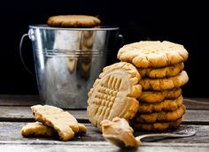 a stack of peanut butter cookies next to a bucket