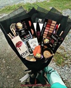 a bunch of makeup on top of a black stand next to a green pole and grass