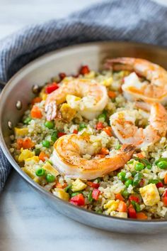 a pan filled with rice and shrimp on top of a table