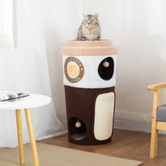 a cat is sitting on top of a house shaped like a coffee cup with its eyes closed