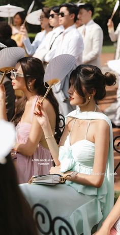 a group of people standing around each other with umbrellas in their hands and one woman holding a purse