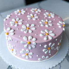 a pink and white decorated cake sitting on top of a table