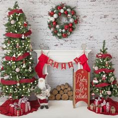 three christmas trees decorated with red and white ribbons, bows, and ornaments in front of a fireplace