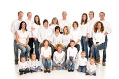 a large group of people posing for a family photo in front of a white background