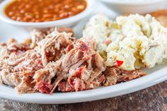 a white plate topped with meat and mashed potatoes