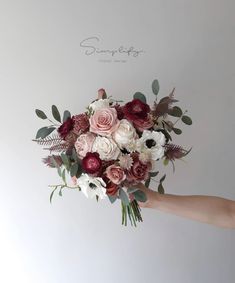 a person holding a bouquet of flowers in their hand