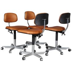 three office chairs with wheels and leather seats