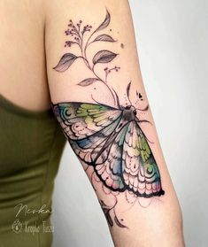 a woman's arm with a colorful butterfly tattoo on the left side of her body