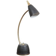 a black and gold desk lamp on a white background, with the light turned off