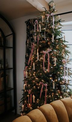 a decorated christmas tree with candles and ribbons