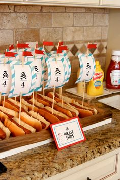 a table topped with lots of hot dogs covered in toppings