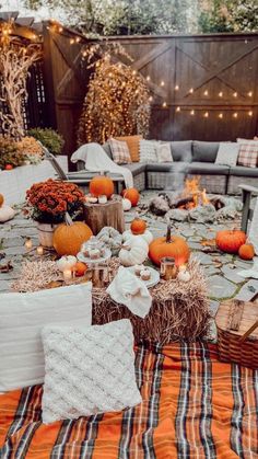 a table with pumpkins, hay and candles on it