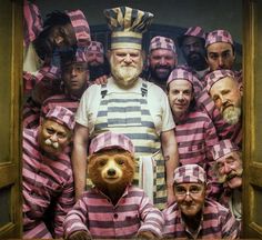 a group of people dressed in pink and grey striped pajamas with a bear mask on