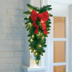 a christmas tree with red bows hanging from it's side on the front door