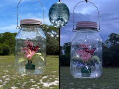 two glass jars with flowers in them hanging from the same wire, and one is empty