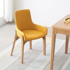 two yellow chairs sitting next to each other on top of a carpeted room floor