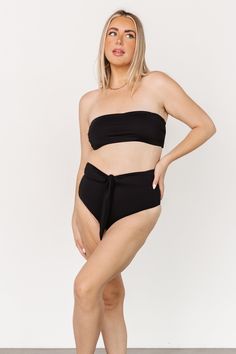 Baltic Born best-seller! Classic black color Tie back bandeau style bikini top Removable padded cups Adjustable to fit most body types 80% Nylon, 20% Spandex Hand wash cold, lay flat to dry Trina is 5'6, cup size 32D, size 2 and is wearing size S Victoria is 5'7, cup size 34D, size 8/10 and wearing size L Black Bandeau Swimwear For Pool, Black Bandeau Swimwear For Swimming, Black Bandeau Tankini For Swimming, Black Bandeau Tankini For Sunbathing, Black Strapless Tankini For Pool, Black Bandeau Tube Top For Swimming, Black Strapless Swimwear For Beach Season, Black Strapless Tube Top For Poolside, Strapless Black Tankini For Pool