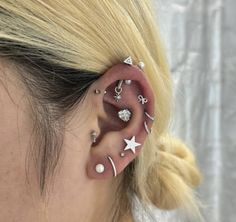 a woman with ear piercings that have stars and moon designs on it's ears