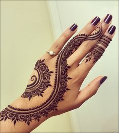 a woman's hand with henna tattoos on it