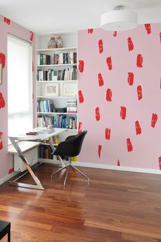 a room with pink walls and red wallpaper in the shape of lipstick kisses on it