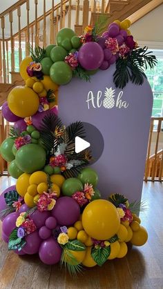 an arch made out of balloons and flowers with the words aloha on it