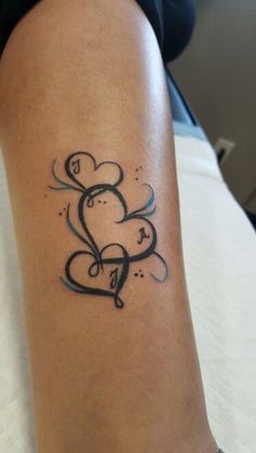 a woman's arm with a tattoo on it that has two hearts in the middle