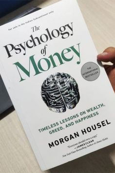 a person holding up a book in their hand with the title'the psychology of money '