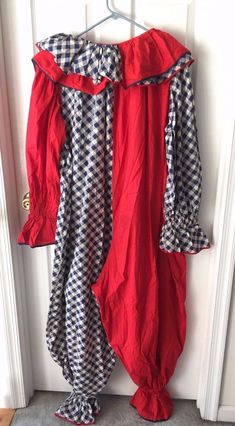 a red and black checkered dress hanging on a door