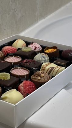 a white box filled with assorted chocolates on top of a counter