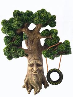 a sculpture of a tree with a man's face on it and a tire