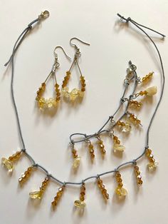 With these citrine amber accessories, create a chic delicate look in pale golden yellow and amber shades. The dangle earrings and necklace carry similar eye-catching allure with subtle glitter in the bracelet. The jewelry set includes a necklace, earrings, and a bracelet. Gemstone - Citrine Beads - Bicone faceted crystal glass beads Color - Pale yellow, amber Earring Style - Teardrop hoop Necklace and bracelet closure - Lobster claw Other materials - Gray beading thread, metal hoops, metal frenc Amber Accessories, Hoop Necklace, Beading Thread, Citrine Beads, Amber Earrings, Earrings And Necklace, Amber Necklace, Bracelet Gemstone, Faceted Crystal