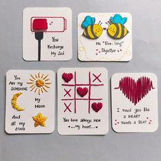 four coasters with different designs on them, one has a bee and the other has a heart