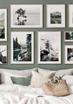 a bed with white sheets and pictures on the wall above it, along with a wicker basket