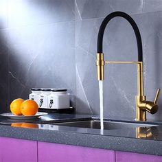 a kitchen sink with a faucet and some oranges on the counter top