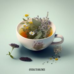 a tea cup filled with flowers and herbs