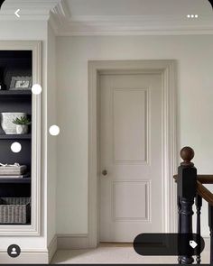 an open door in a white room with black and white accessories on the shelves above it