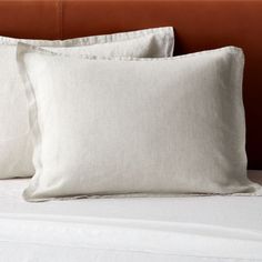 two white pillows sitting on top of a bed