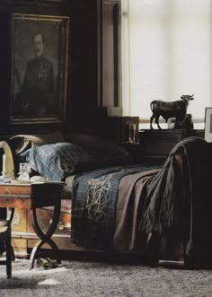 a bedroom with a bed, chair and painting on the wall next to a window