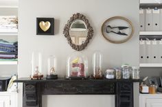 there is a mantle with many items on it and a mirror hanging above the mantle