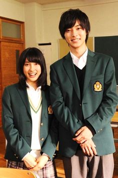 two people standing next to each other in school uniforms