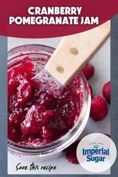 cranberry pomegranate jam in a jar with a wooden spoon