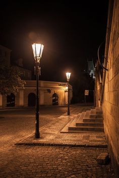 an empty street at night with steps lit up