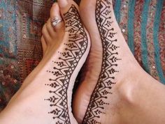 two feet with henna tattoos on them