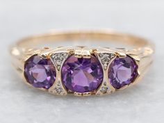 Get your sparkle on with this Victorian style ring featuring stunning amethysts and diamond accents. Perfect for adding a touch of vintage glamour to any outfit! Metal: 14K Yellow and White Gold Gem: 3 Amethyst, 4 Diamond totaling .02 Carats, G-I in Color, SI in Clarity Width of Band: 5.7 mm Height off Finger: 4.0 mm Ring Size: 7 Marks: "14K+W" Stamped on the inside band SKU #: A44955 Each piece has been identified and graded by a Graduate Gemologist who has been certified by the Gemological Institute of America (GIA). We have six brick-and-mortar storefronts in Maine, Massachusetts, and New Hampshire and have been in business for over 25 years! Please visit our Shop's About Page or our website for more information about our jewelry. For questions about diamond grading, we recommend the  G Victorian Amethyst Ring With Center Stone, Luxury Victorian Amethyst Ring In Purple, Victorian Amethyst Ring In Yellow Gold, Victorian Style Hallmarked Amethyst Ring, 14k Gold Victorian Amethyst Ring, Victorian Style Rings, Amethyst And Diamond Ring, Victorian Rings, February Birth Stone