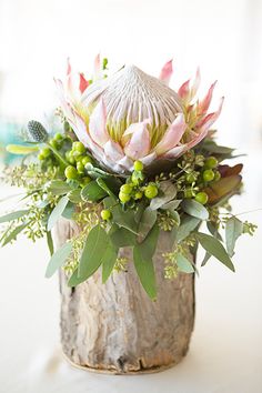 an arrangement of flowers in a wooden vase