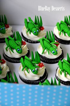 cupcakes decorated with green icing and dragon decorations