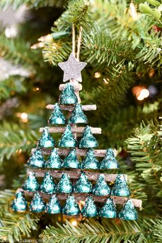 a christmas tree ornament made out of wood sticks and blue glittered cones