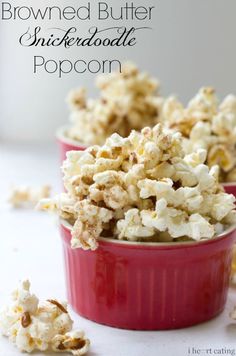 two red bowls filled with popcorn on top of a table